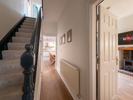 A hallway with a staircase and an open door leading to a living area at 22 Ashville Avenue in Scarborough