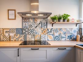 A kitchen with patterned tiles and a shelf holding plants at 22 Ashville Avenue in Scarborough
