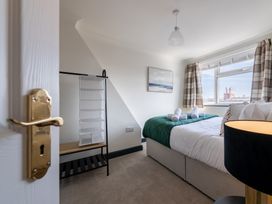 A bedroom with a bed and a shelf unit at 22 Ashville Avenue in Scarborough