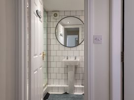 A bathroom featuring a circular mirror and a sink at 22 Ashville Avenue in Scarborough