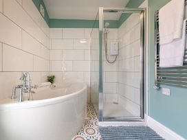 A bathroom with a bath tub and shower enclosure at 22 Ashville Avenue, Scarborough
