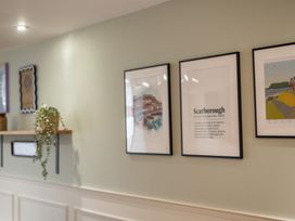 A cozy wall with framed artwork and a shelf with a plant at The Ravines in Scarborough