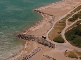 A beach with rocks and a pathway near the ocean at Hoburne Naish - HE16 Seaclusion in New Milton