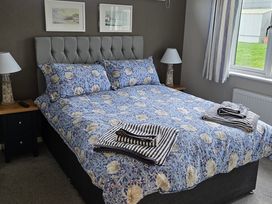 A bedroom with a bed and bedside table at Hoburne Naish - HE16 Seaclusion in New Milton