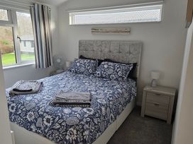A bedroom with a bed and bedside lamp at Hoburne Naish - HE16 Seaclusion New Milton