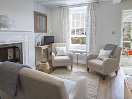 A living room with chairs and a television at Primrose Cottage in Salcombe