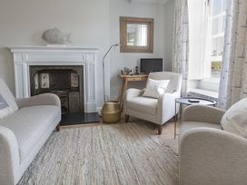 A living room with a fireplace and armchairs at Primrose Cottage Salcombe