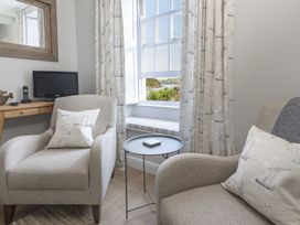 A living room with an armchair and television at Primrose Cottage Salcombe