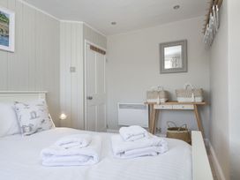 A bedroom with a bed and a table at Primrose Cottage, Salcombe