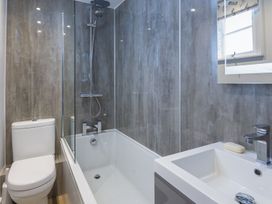 A bathroom with shower, bathtub, sink, and toilet at Primrose Cottage Salcombe