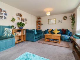 A living room with a sofa, coffee table and bookshelf at Manning's View in Barnstaple