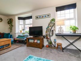 A living room with a television and shelves at Manning's View in Barnstaple