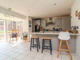 A kitchen with an island and stools at Manning's View in Barnstaple