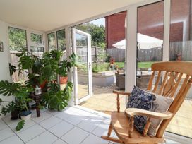 A conservatory with a rocking chair and plants at Manning's View in Barnstaple