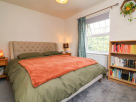 A bedroom with a bed and bookshelf at Manning's View in Barnstaple