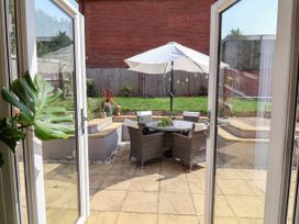A garden with patio furniture and an umbrella at Manning's View in Barnstaple