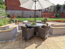 A garden with a table and chairs under an umbrella at Manning's View Barnstaple