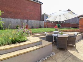 A garden with a table and chairs under an umbrella at Manning's View Barnstaple