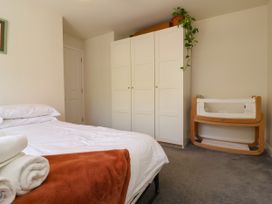 A bedroom with a bed and baby crib at Manning's View in Barnstaple