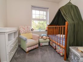 A nursery with a crib and armchair at Manning's View in Barnstaple