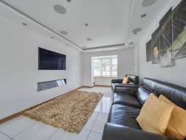 A living room with a television and sofa at The Old Barn in Abergele