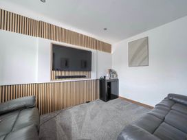 A living room with a television and a sofa at the property in Abergele