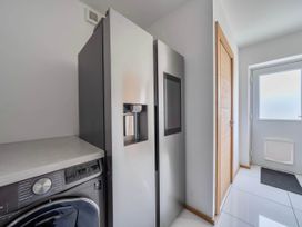 A laundry room with a refrigerator and washing machine at The Old Barn in Abergele