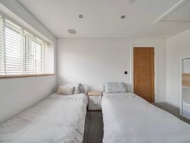 A bedroom with two beds and a nightstand at The Old Barn in Abergele