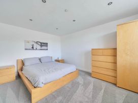 A bedroom with a bed and dresser at The Old Barn in Abergele