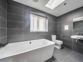 A bathroom with a bath tub and toilet at The Old Barn in Abergele