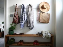 An entryway with coats and a hat on hooks and shoes on a bench at Beautiful 6Bed Sleeps 12 Stunning Views in Lynton