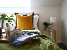 A bedroom with a bed, pillows, plant, and cups at Beautiful 6Bed Sleeps 12 Stunning Views, Lynton