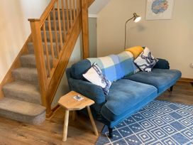 A living room with a sofa and staircase at 1 bed cottage Parking Patio close to coasts Coads Green near Launceston