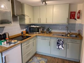 A kitchen with cabinets, stove, sink, microwave at 1 bed cottage Parking Patio close to coasts Coads Green near Launceston