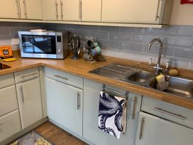 A kitchen with a sink and microwave at 1 bed cottage Parking Patio close to coasts Coads Green near Launceston
