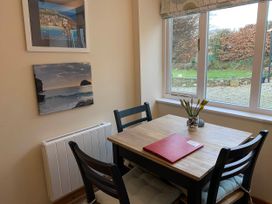 A dining room with a table and chairs at 1 bed cottage Parking Patio close to coasts Coads Green near Launceston