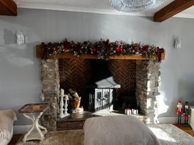 A living room with a fireplace and decorative garland at Build your memories hot tub garden sleeps 14 in Nottage
