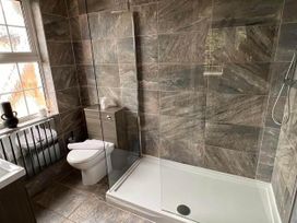 A bathroom with a toilet, sink, and shower at Build your memories hot tub garden sleeps 14 in Nottage