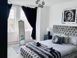 A bedroom with a bed and a mirror at Build your memories hot tub garden sleeps 14 in Nottage