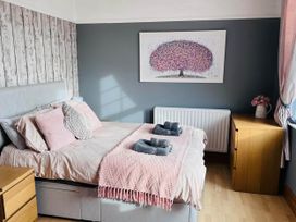 A bedroom with a bed and wall art at Build your memories hot tub garden sleeps 14 Nottage