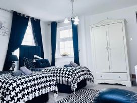 A bedroom with two beds and a wardrobe at Build your memories hot tub garden sleeps 14 in Nottage
