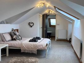 A bedroom with a bed and a door leading to a bathroom at Build your memories hot tub garden sleeps 14 Nottage