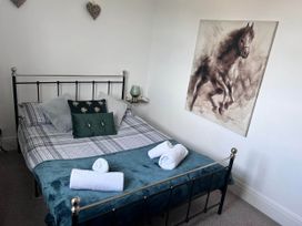 A bedroom with a bed and wall art at Build your memories hot tub garden sleeps 14 in Nottage
