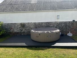 A hot tub on a wooden deck surrounded by grass at Build your memories hot tub garden sleeps 14 Nottage