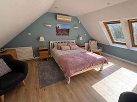A bedroom with a bed and windows at River Tamar Couples Retreat Dog Friendly in Newbridge