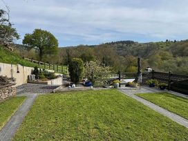 A garden with a fence and flower beds at River Tamar Couples Retreat Dog Friendly Newbridge