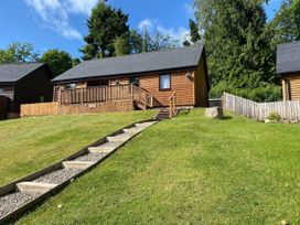 A lodge with wooden exterior and deck at Blairgowrie Luxury 3 Bed Lodge with Hot Tub in Blairgowrie