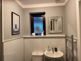 A bathroom featuring a sink, toilet, mirror and a window at Blairgowrie Luxury 3 Bed Lodge with Hot Tub in Blairgowrie