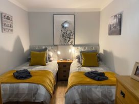 A bedroom with two beds and a bedside table at Blairgowrie Luxury 3 Bed Lodge with Hot Tub in Blairgowrie