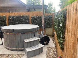 A hot tub with a stove and steps outside at Blairgowrie Luxury 3 Bed Lodge with Hot Tub, Blairgowrie